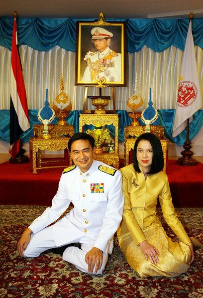 Abhisit Vejajjiva, head of the government after the coup, here seen in military regalia, kneeling beneath an image of the king.