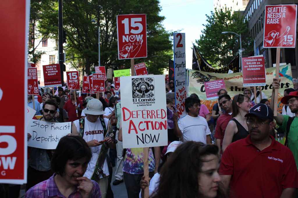 Deferred Action refers to the deferral of deportation procedures. But in this image, the phrase communicates the oxymoronic ambiguity of the protestors' demands, targetted at President Obama.